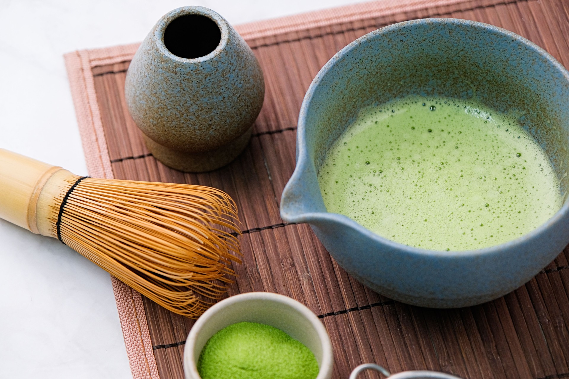 Traditional matcha kit, Bamboo whisk and beverage on bamboo mat in the kitchen