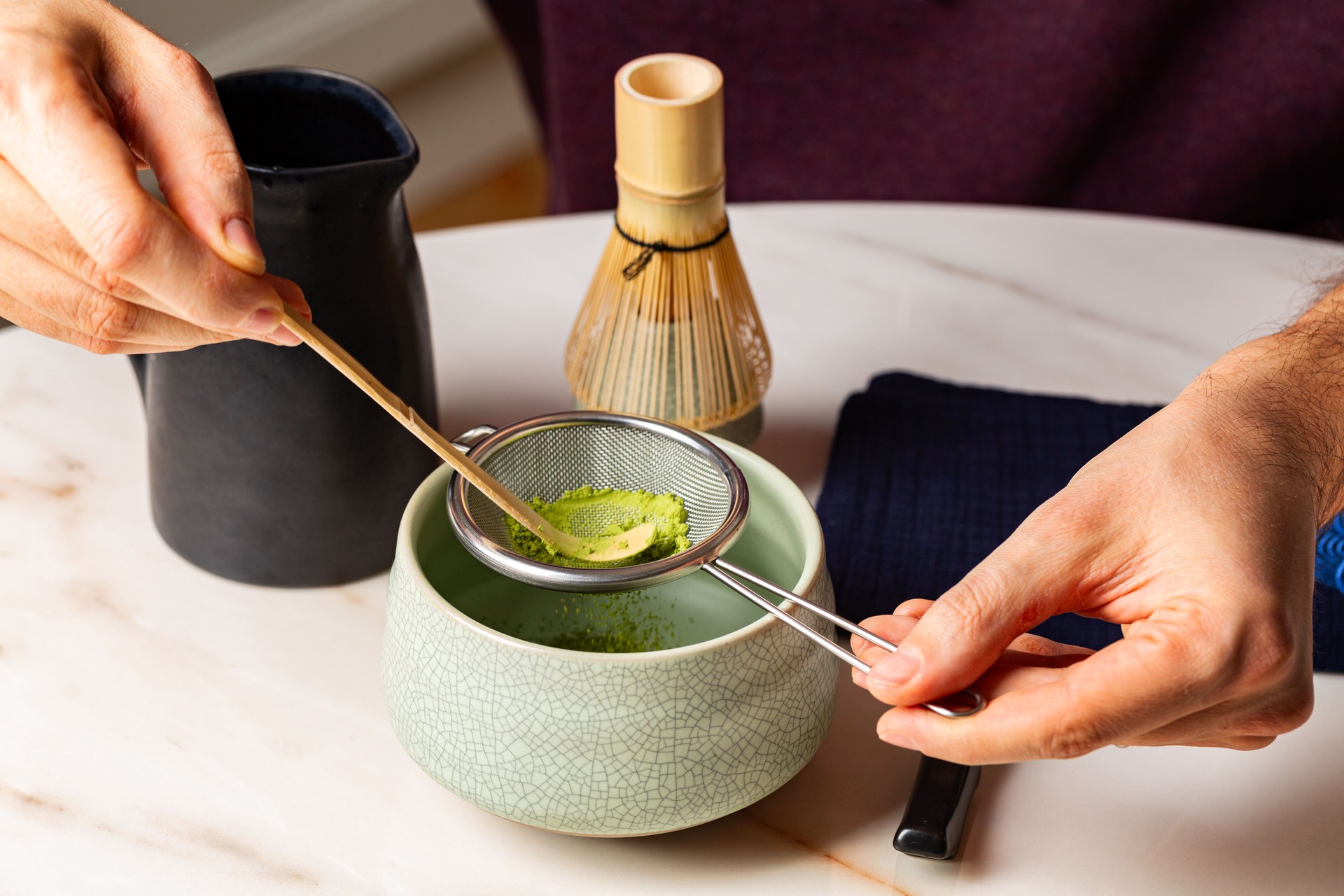 Man hands, Cooking green matcha tea during the Japanese ceremony. Traditiobal kit, Bamboo whisk and beverage, spoon shashaku, heated tea bowl known as a chawan. Horizontal image.